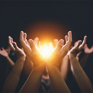 Plusieurs mains tendues vers une lumière brillante, créant une énergie collective