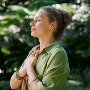 Une femme, mains jointes sur la poitrine, exprimant de la gratitude